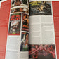 Open magazine with movie posters and text on a dark surface